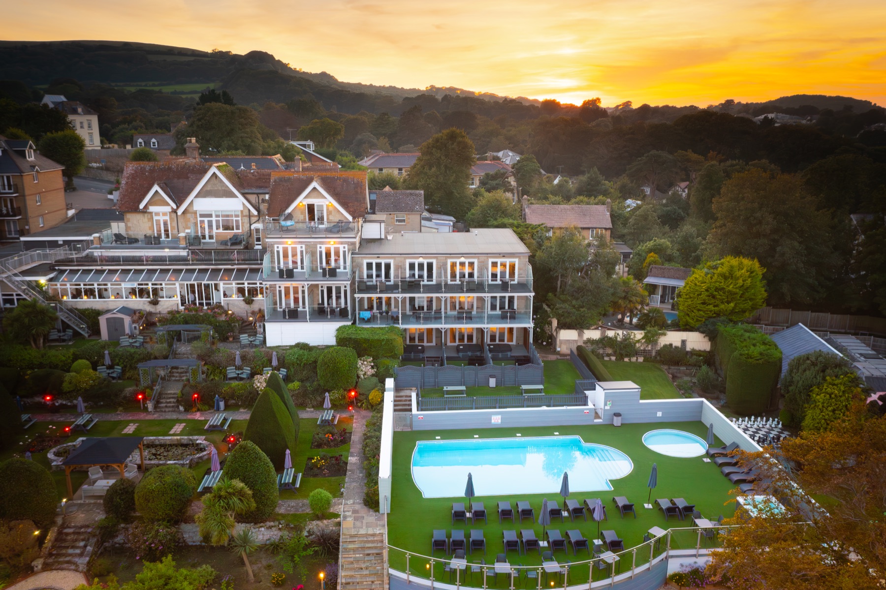 Luccombe Hall at sunset — aerial view over the hotel and pool