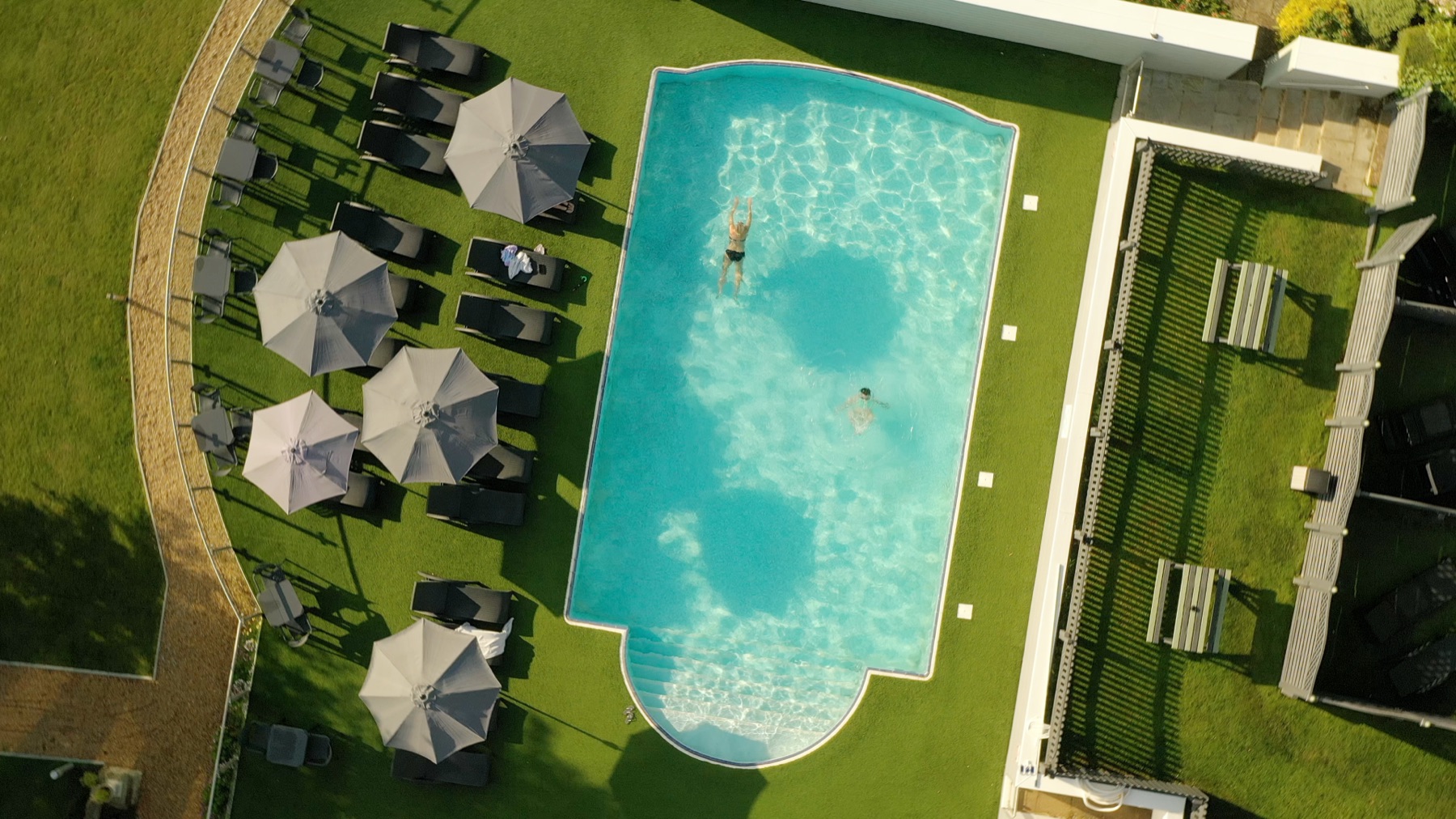 Top-down drone shot of the outdoor swimming pool and sun terrace